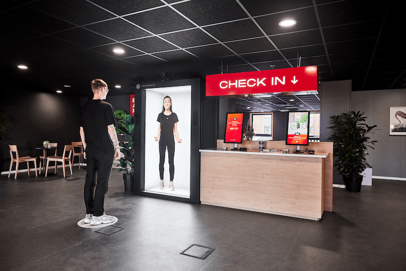 A life-like holographic person standing in a room.